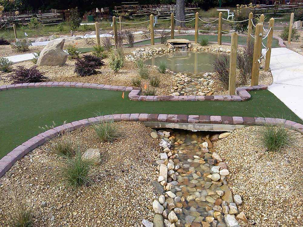 Water flowing under the mini golf course at RALEIGH OAKS RV RESORT & COTTAGES