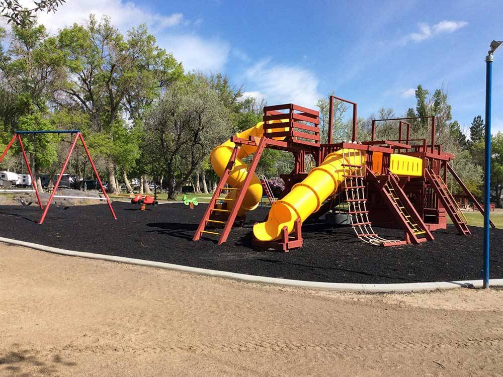 Playground with swing set at SNAKE RIVER RV PARK AND CAMPGROUND
