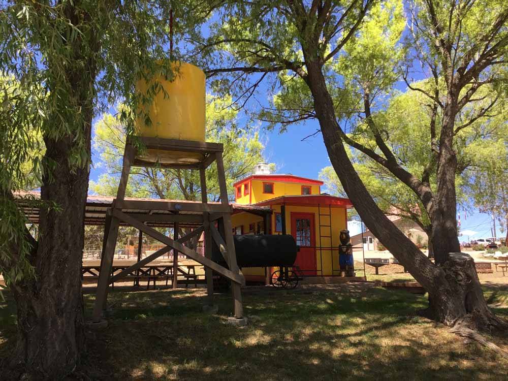 A yellow caboose sitting next to a tree at OASIS DURANGO RV RESORT