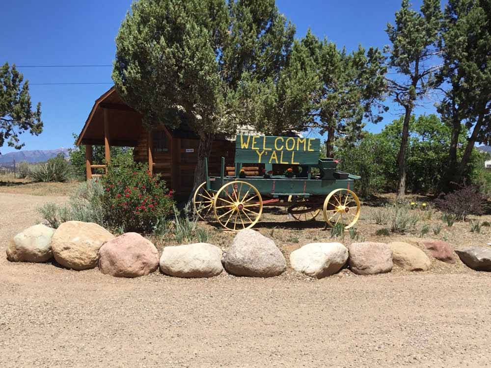 An old wagon with "welcome y'all" painted on the side at OASIS DURANGO RV RESORT