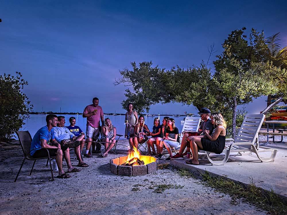 Group of campers enjoying an evening outdoors with campfire at BOYD'S KEY WEST CAMPGROUND