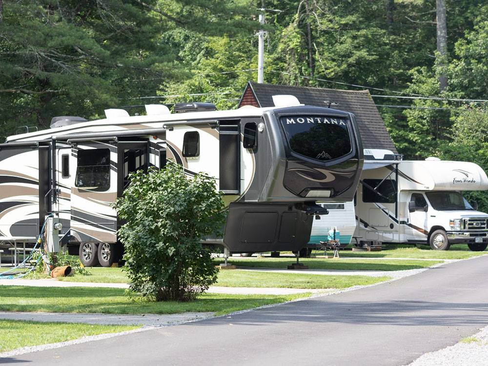 Fifth wheels and trailers parked in paved sites at FIELD & STREAM RV PARK