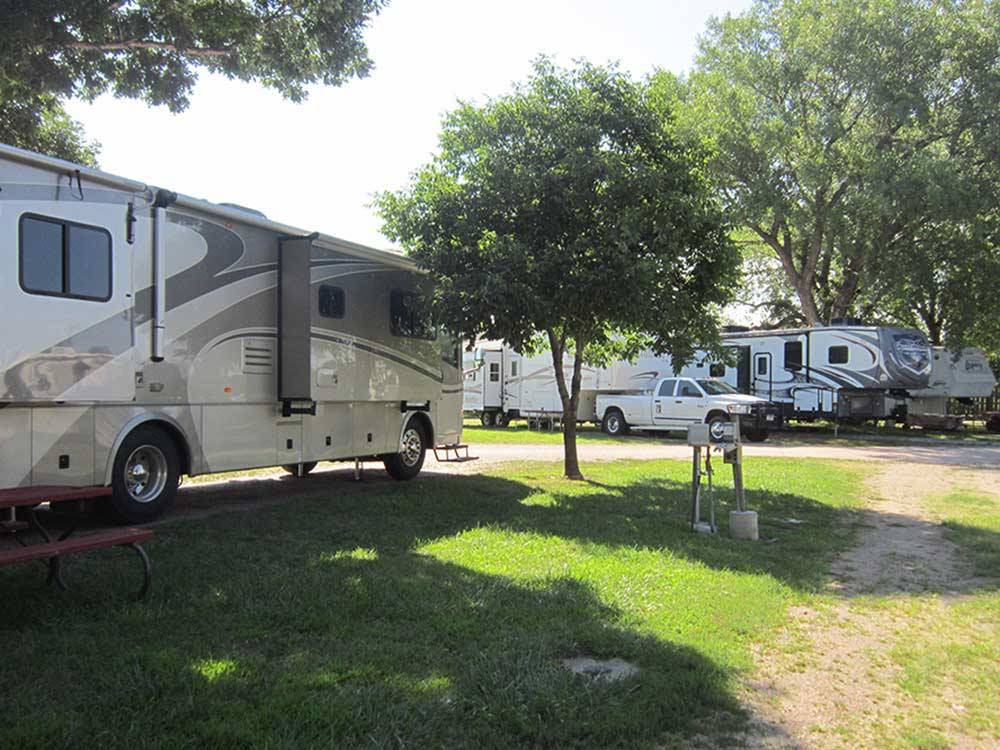 White and grey motorhome parked near brown park bench at HOLIDAY RV PARK & CAMPGROUND