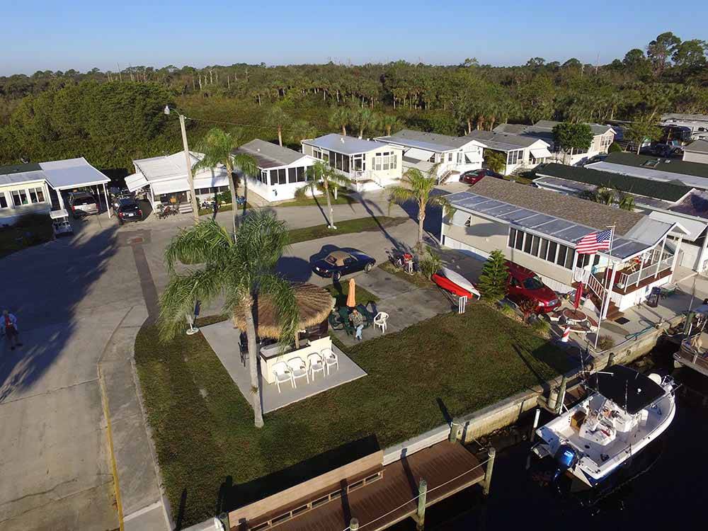 Aerial view of mobile home park with palm trees and American flag at UPRIVER RV RESORT
