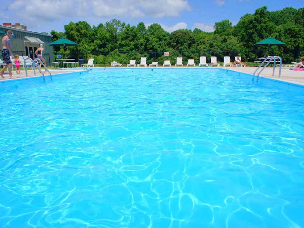 Swimming pool with lounge chairs at AMERICAN HERITAGE RV PARK