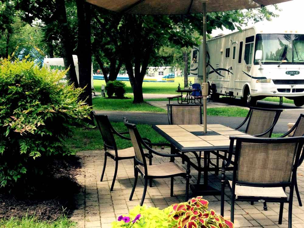 A patio table next to an RV site at AMERICAN HERITAGE RV PARK