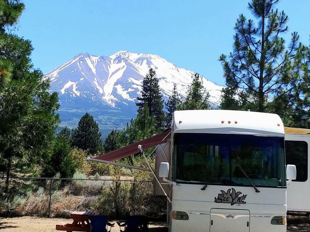 Motorhome in camp with mountain in background at FRIENDLY RV PARK