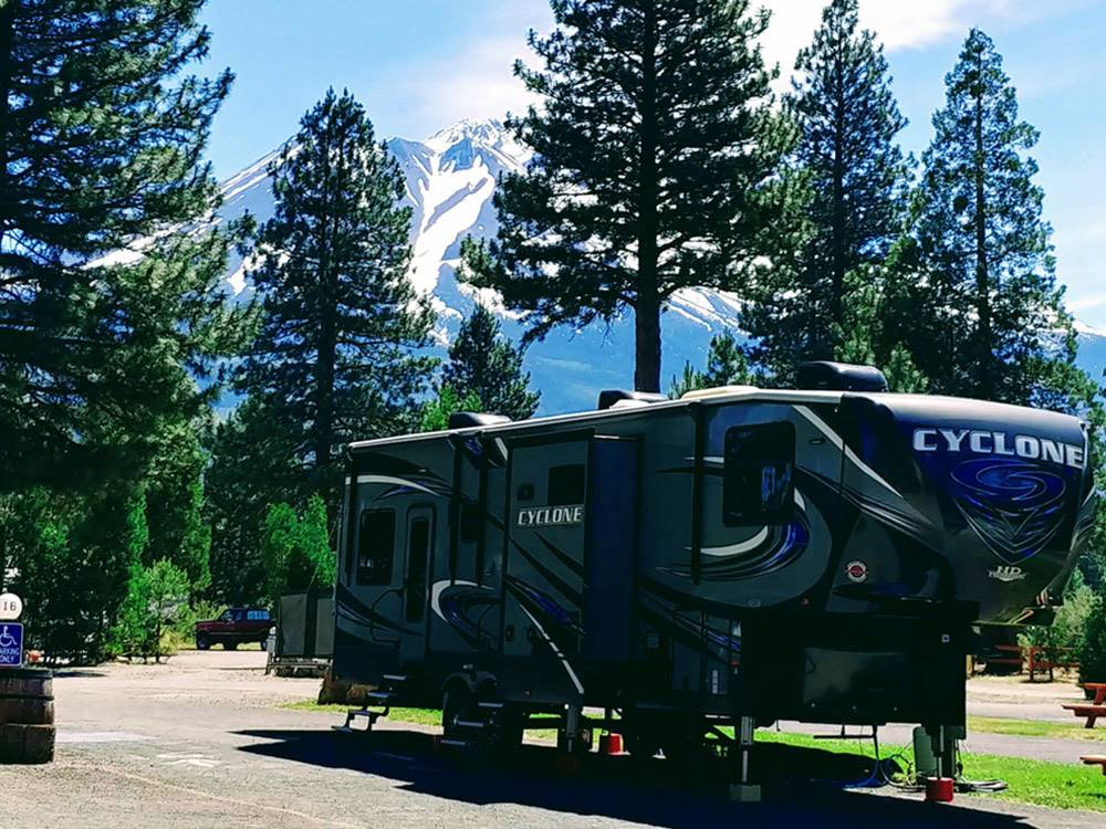 Fifth-wheel on paved site with mountain in background at FRIENDLY RV PARK