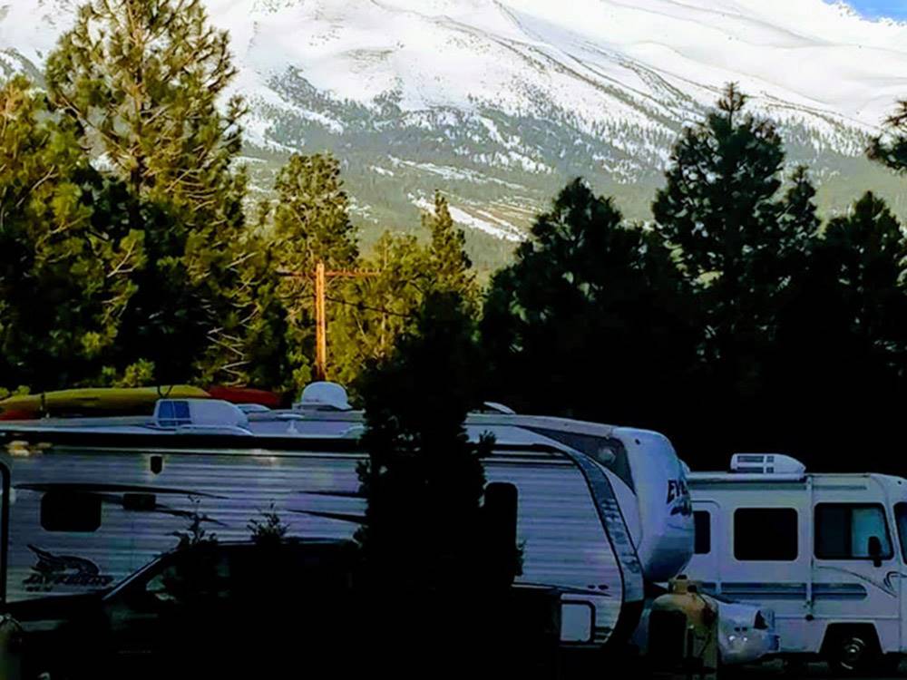 RVs parked in campground with snowy slopes in background at FRIENDLY RV PARK
