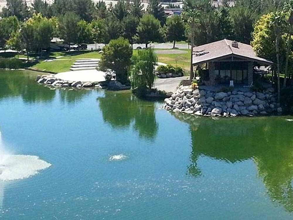 Manicured lake with small building on water's edge at LAKESIDE CASINO & RV PARK