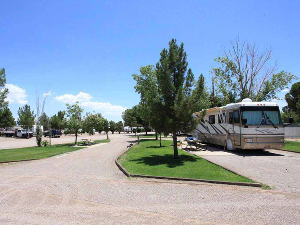 A motorhome parked in a gravel pull thru site at SUNNY ACRES RV PARK