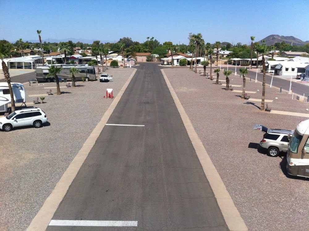 A road in between the gravel pull thru sites at DESERT SHADOWS RV RESORT