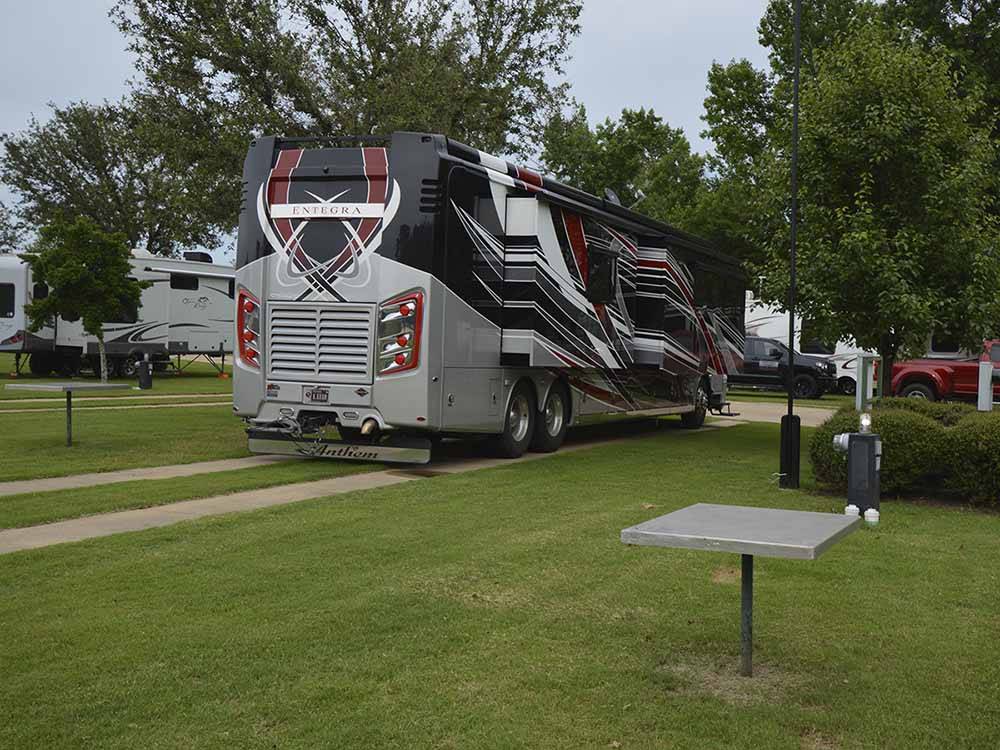 A Class A motorhome pulled in to a gravel site at BUSHMAN'S RV PARK