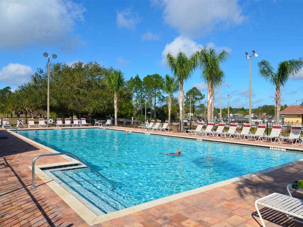 Swimming pool with outdoor seating at THOUSAND TRAILS ORLANDO