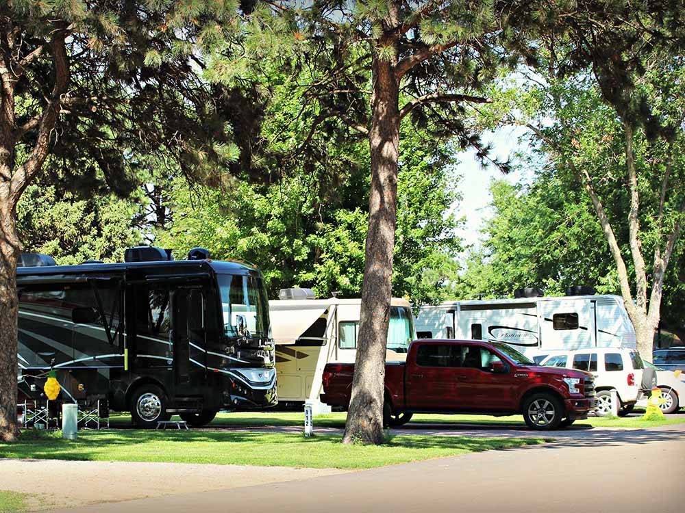 RVs and a truck parked under a tree at TOWER CAMPGROUND