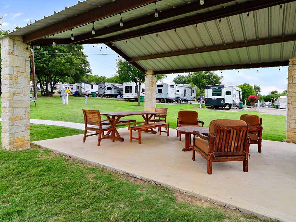 Wooden bench and table with chairs under the pavilion at NORTHLAKE VILLAGE RV PARK