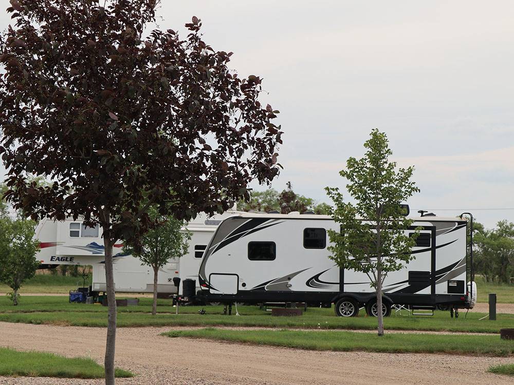 Fifth-wheel and travel trailer camping on sites at CAMPLAND RV RESORT