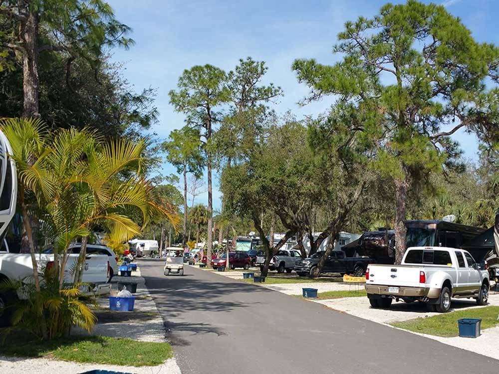 Golf cart on paved road lined with RV sites at SEMINOLE CAMPGROUND