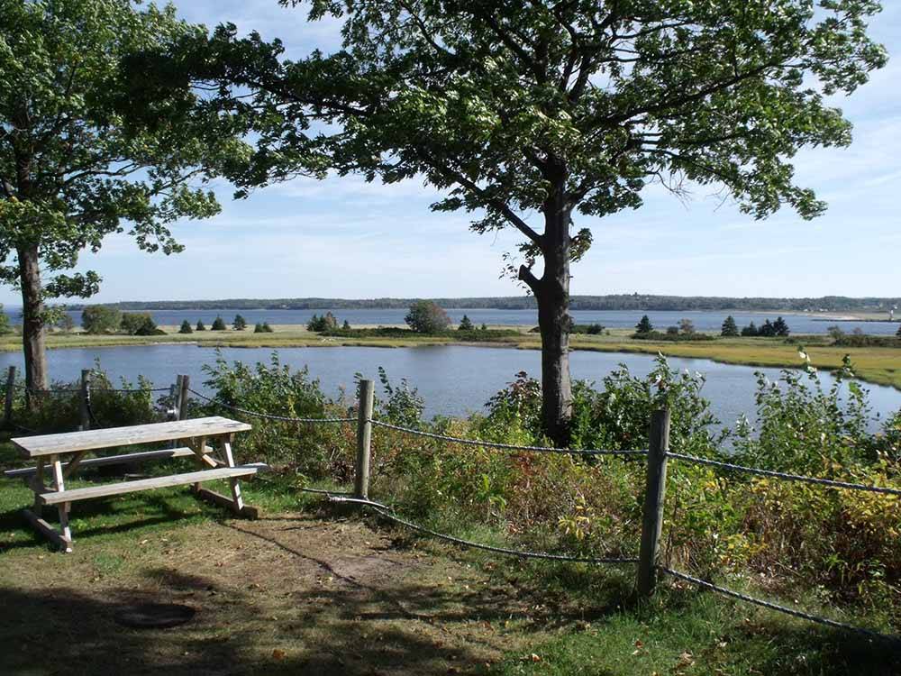 A picnic table by the water at HARBOUR LIGHT TRAILER COURT & CAMPGROUND