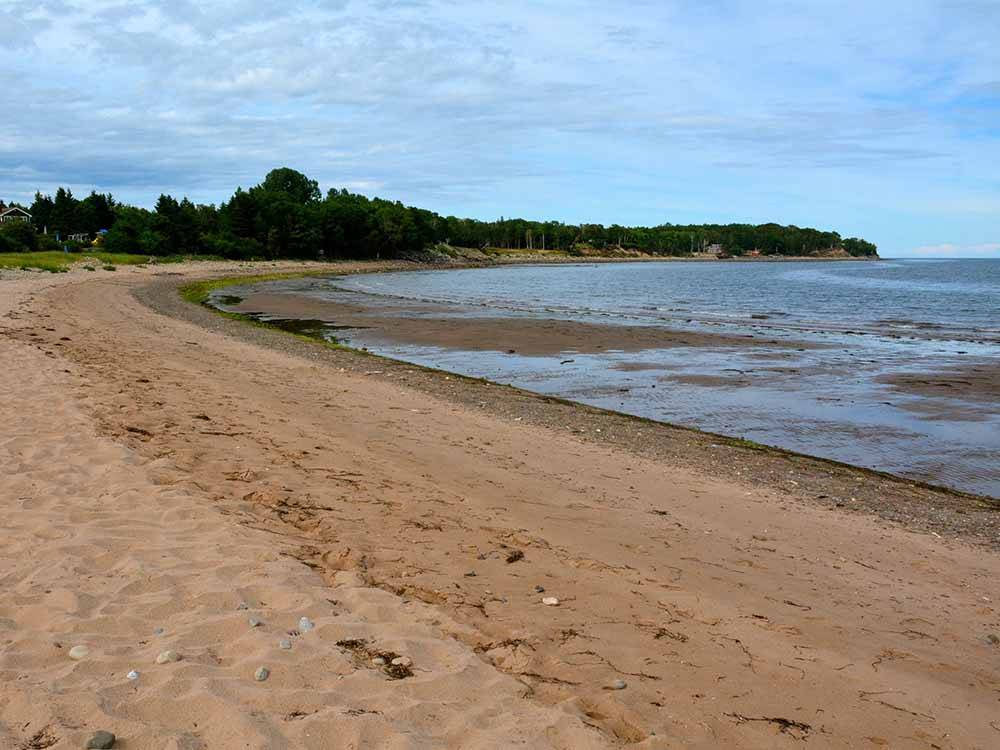 The sandy beach nearby at HARBOUR LIGHT TRAILER COURT & CAMPGROUND