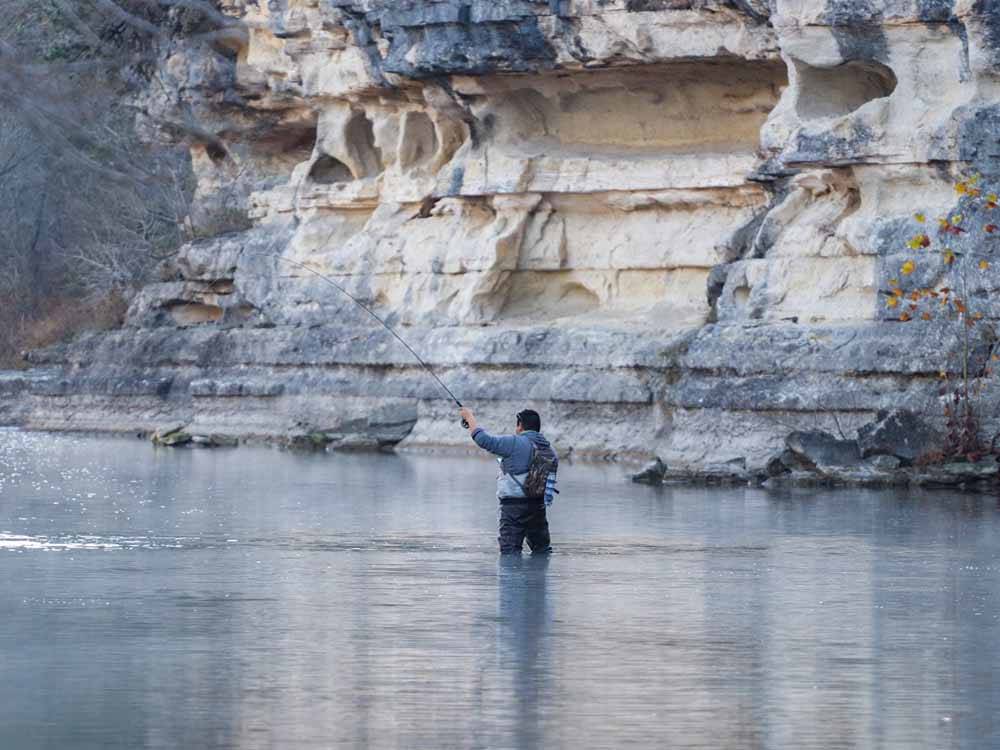 A man fly fishing in the river at RIO GUADALUPE RESORT