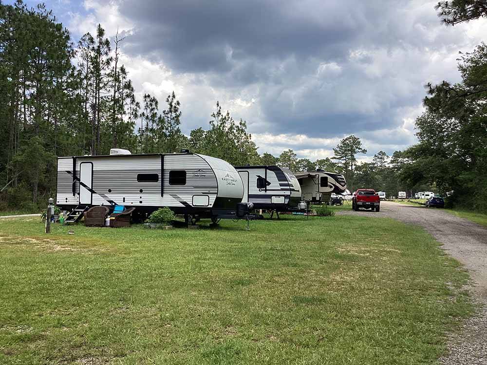 A row of trailers in grassy sites at WILDERNESS RV PARK
