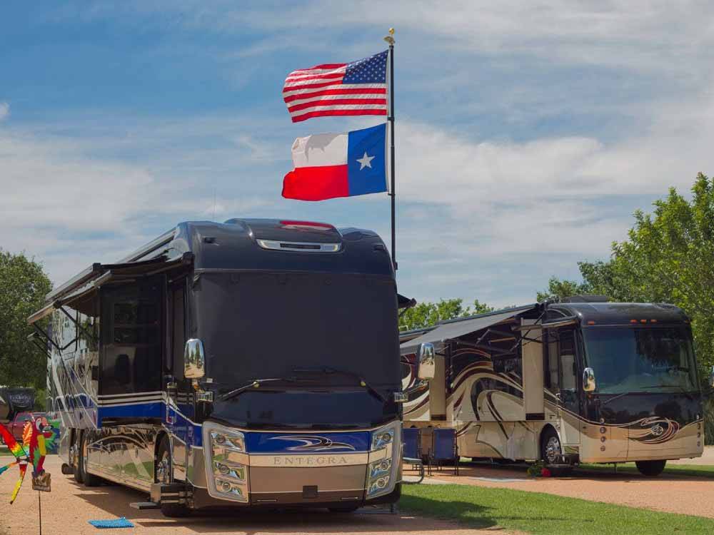 A couple of motorhomes in RV sites at PEACH COUNTRY RV PARK