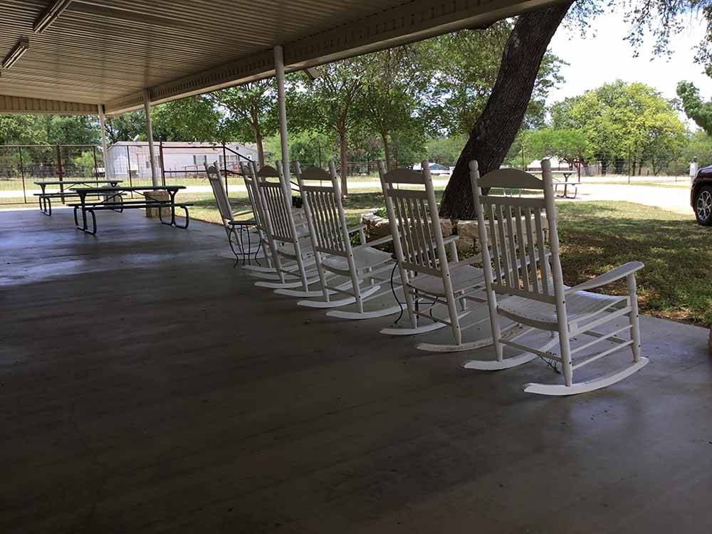 White rocking chairs on the porch at PEACH COUNTRY RV PARK