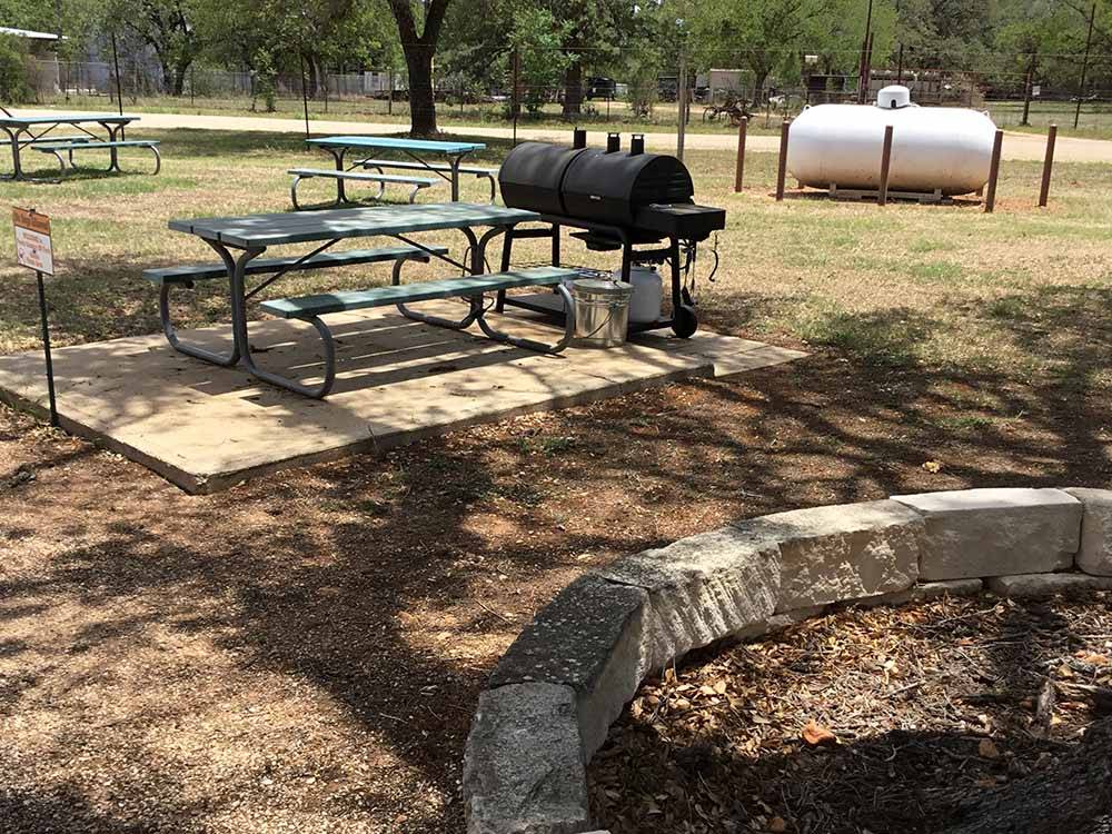 Picnic tables and a meat smoker at PEACH COUNTRY RV PARK