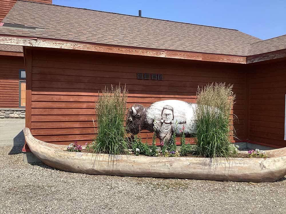 Sculpture of buffalo in planter near building at BUFFALO CROSSING RV PARK