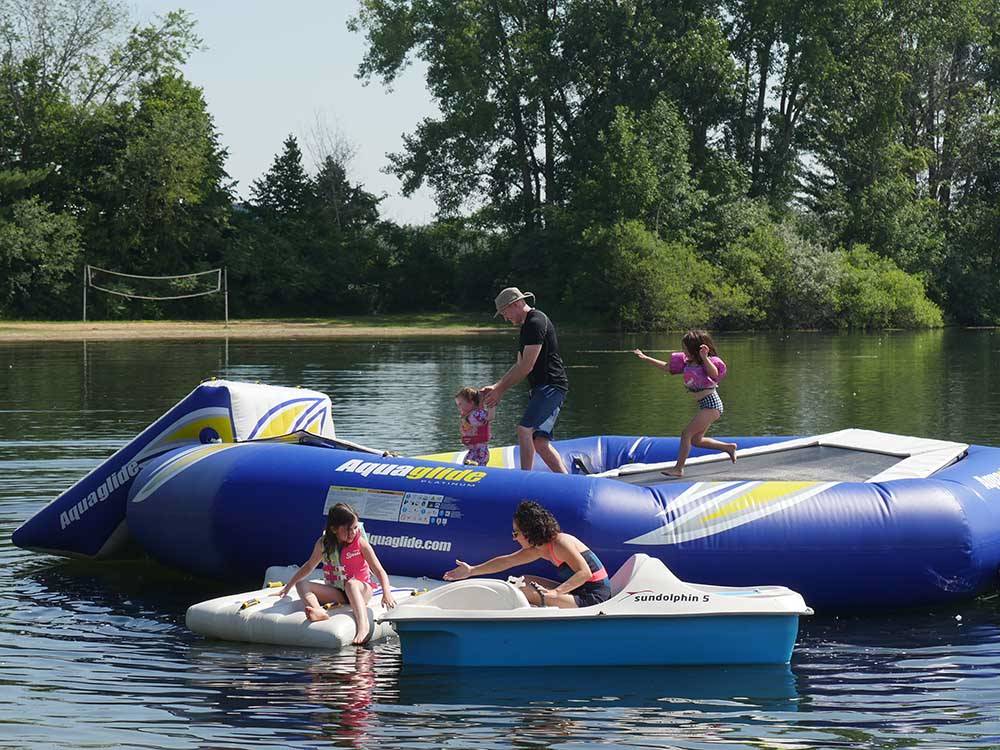 Family playing on inflatable trampoline at SOARING EAGLE HIDEAWAY RV PARK