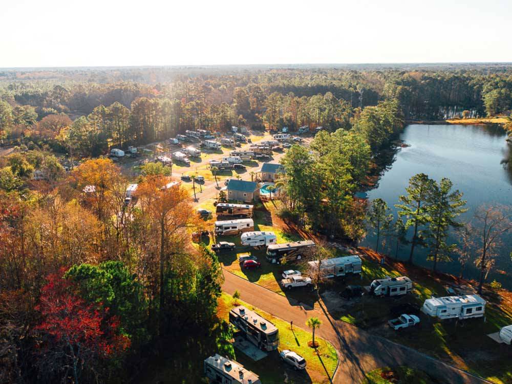 Aerial shot of RVs lined along a lake surrounded by trees at LAKE JASPER RV VILLAGE