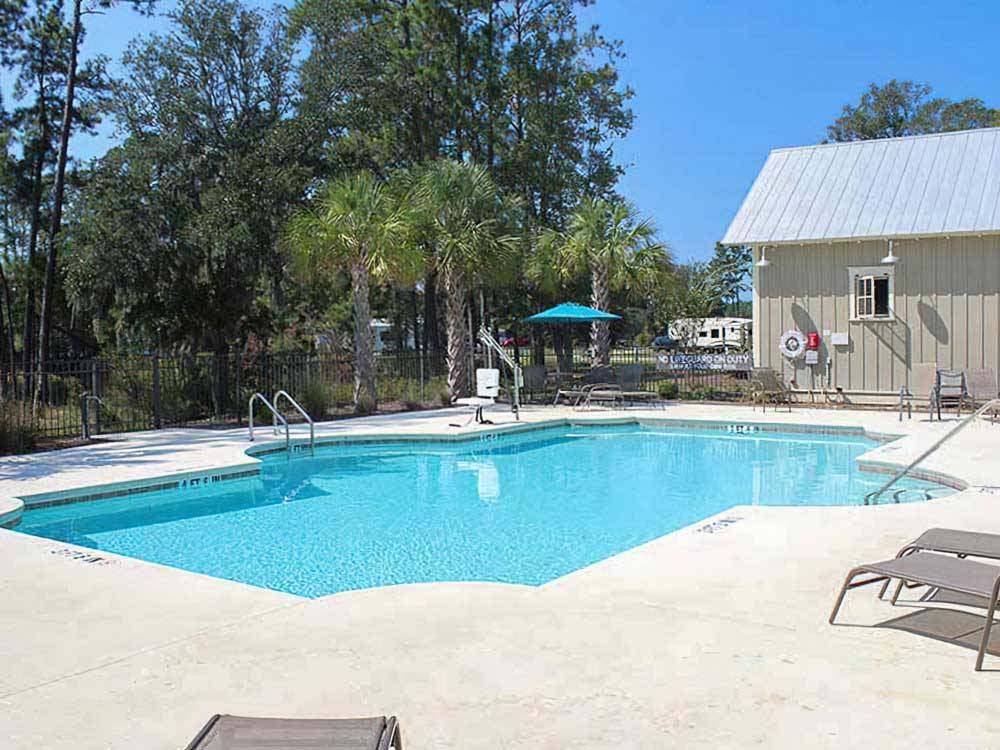 Pool near a building with chaise lounges at LAKE JASPER RV VILLAGE