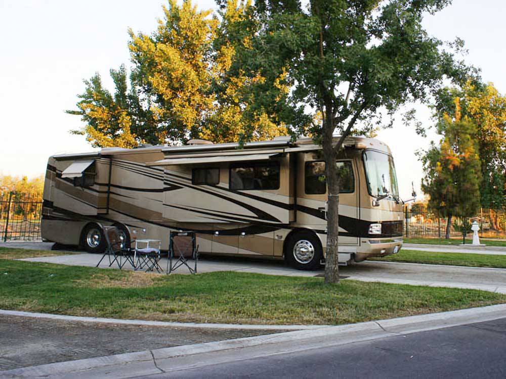 Motorhome in site with patio with chairs at LAKE JASPER RV VILLAGE