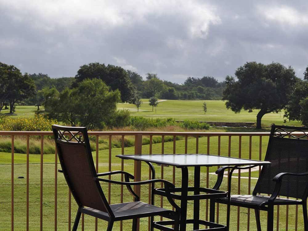 Table and chairs with golf course in background at ALSATIAN RV RESORT & GOLF CLUB