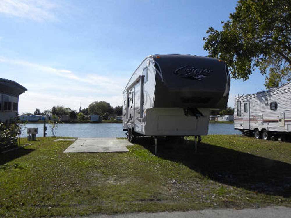 A firth wheel trailer in an RV site by the water at LAZY J RV & MOBILE HOME PARK