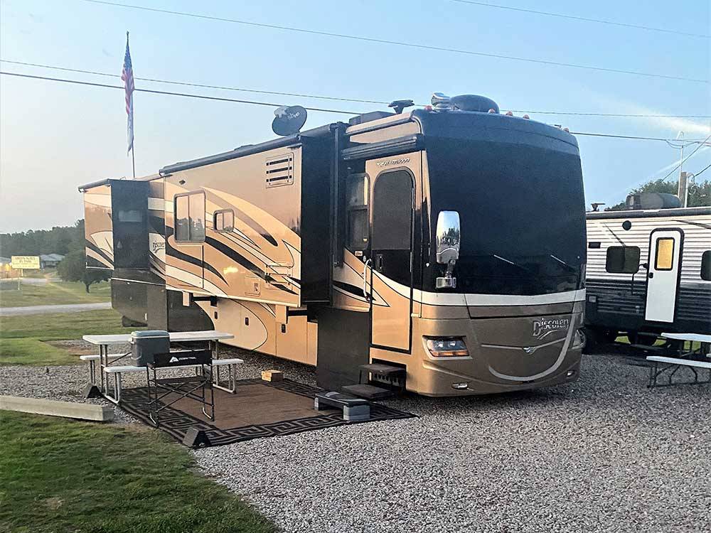 A motorhome and a picnic table at GREEN ACRES RV PARK