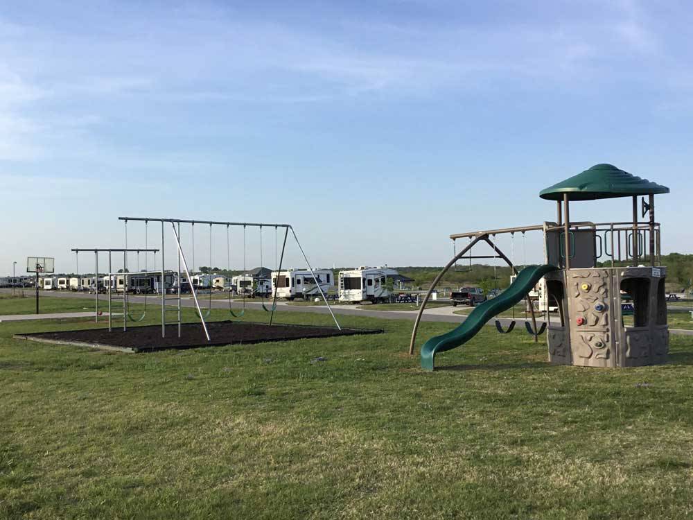 Playground with swing set at BY THE LAKE RV PARK