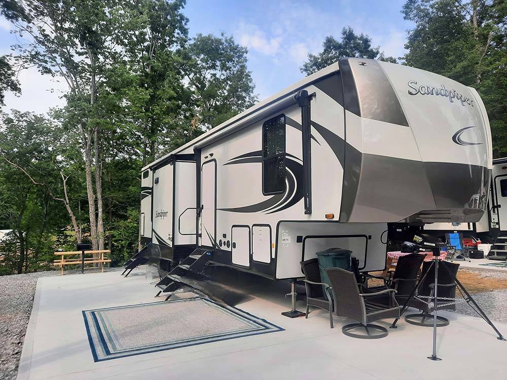 A fifth wheel trailer parked in a concrete site at LAUREL LAKE CAMPING RESORT