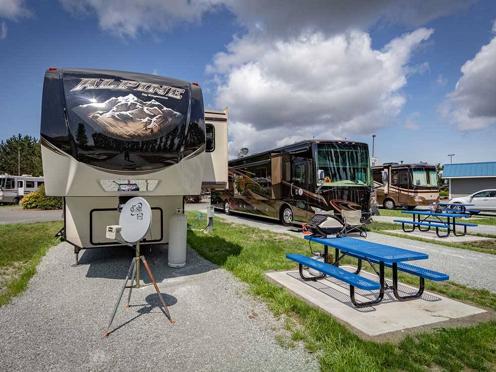RVs in large gravel sites with a blue picnic tables at LA CONNER MARINA & RV PARK