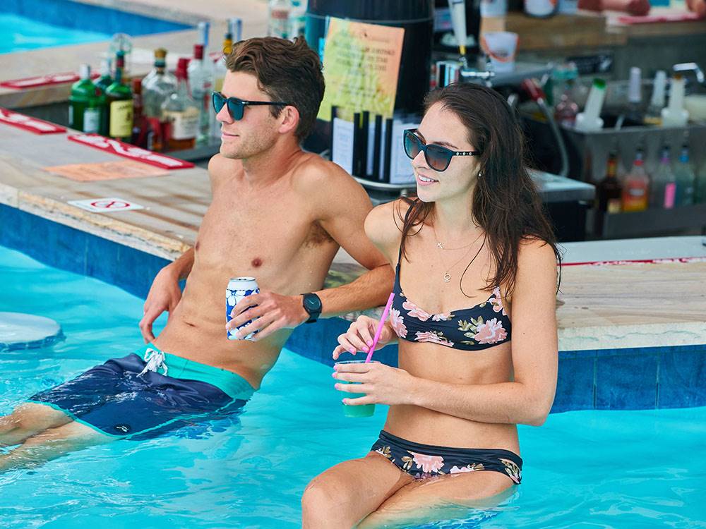 A couple enjoying drinks at the bar in the swimming pool at SUN OUTDOORS REHOBOTH BAY