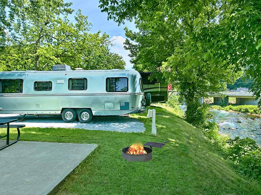 A row of RV sites by the river at RIVEREDGE RV PARK & CABIN RENTALS