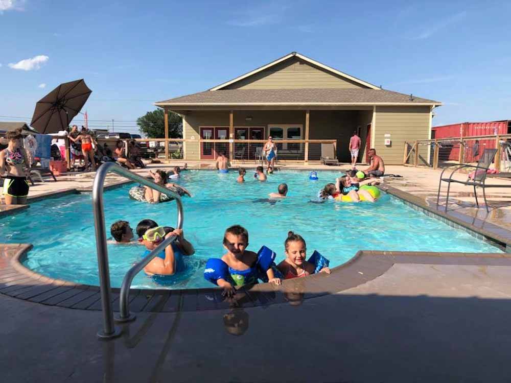 Kids having fun in the blue pool at WHISTLE STOP RV RESORT
