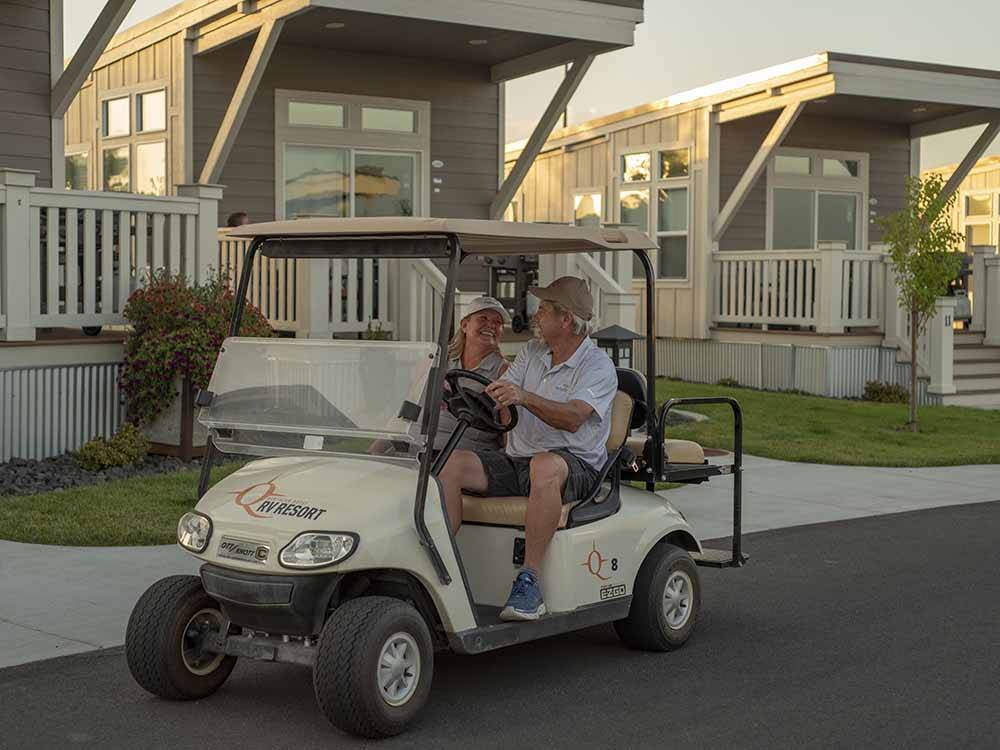 A couple driving a golf cart at NORTHERN QUEST RV RESORT