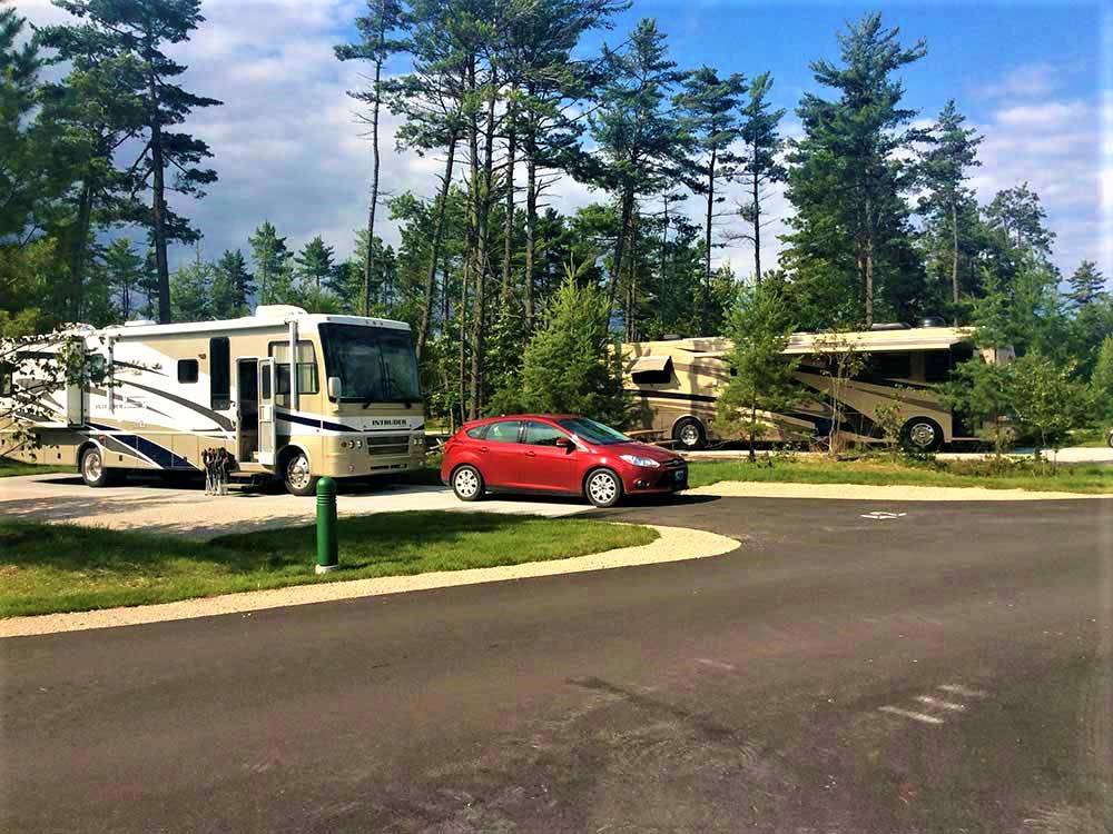 Motorhomes in paved sites with dinghy car at MANISTIQUE LAKESHORE CAMPGROUND
