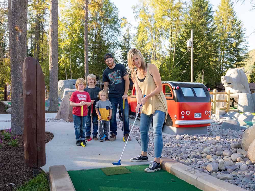 Family playing miniature golf at WEST GLACIER RV PARK & CABINS