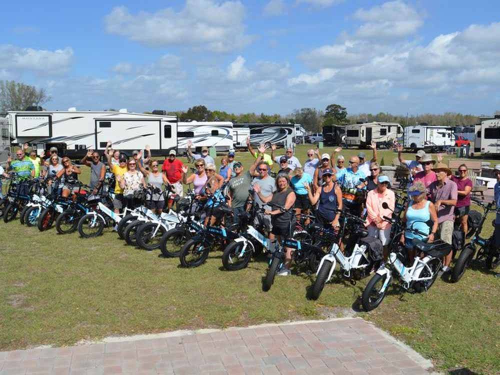 A group of people standing next to bikes at SUNKISSED VILLAGE RV RESORT