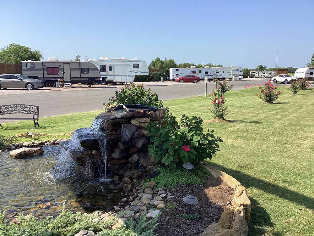 A water fountain with RV sites in the back at DO DROP INN RV RESORT & CABINS