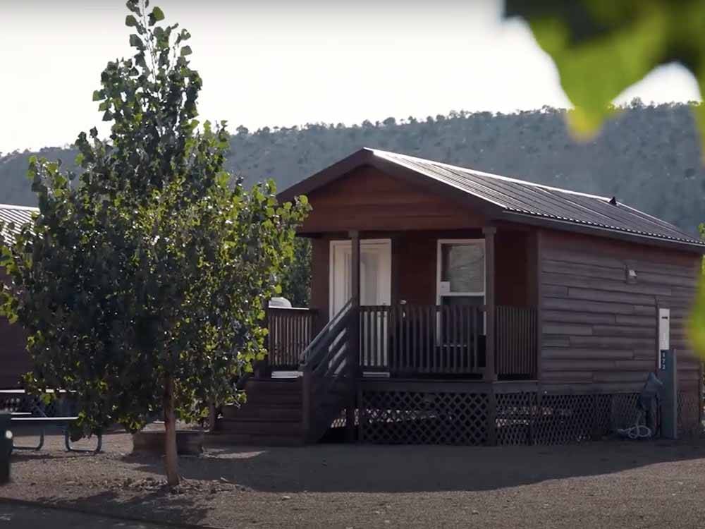 A wooden cabin with a deck at CASTLE GATE RV PARK & CAMPGROUND