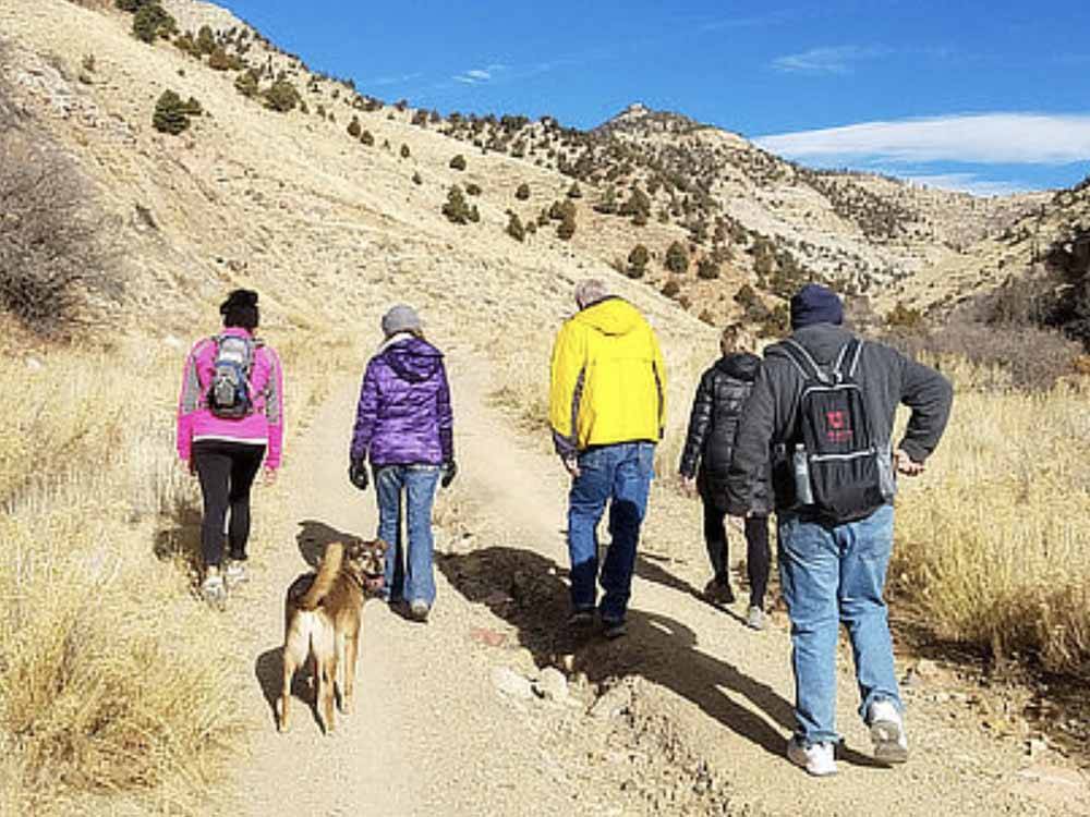 Family and dog hiking at CASTLE GATE RV PARK & CAMPGROUND
